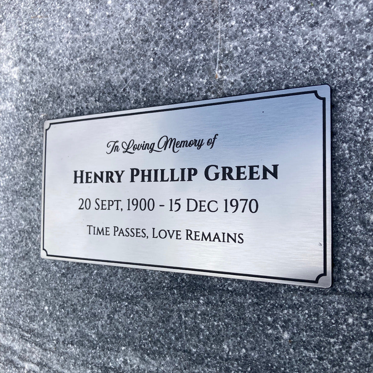 Memorial plaque for Henry Phillip Green on a textured gray granite background
