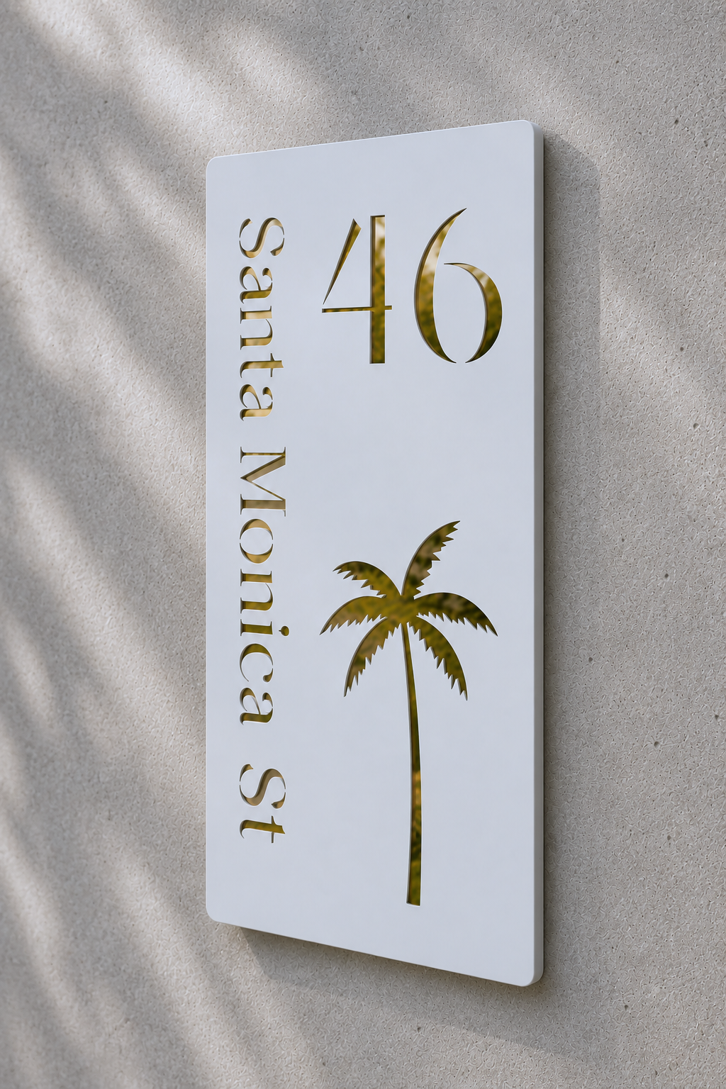 White sign with gold text and palm tree on a beige wall