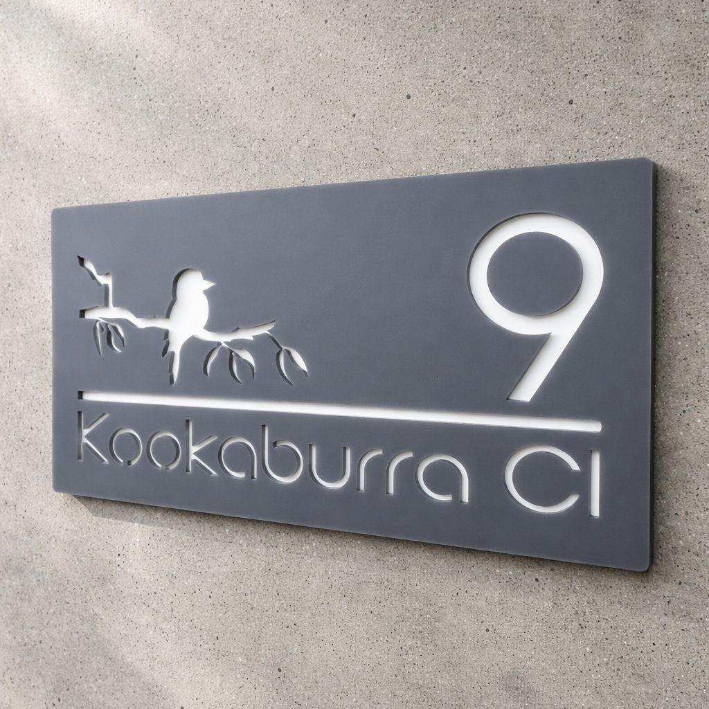 Decorative house number sign with '9' and 'Kookaburra Cl' on a concrete wall.