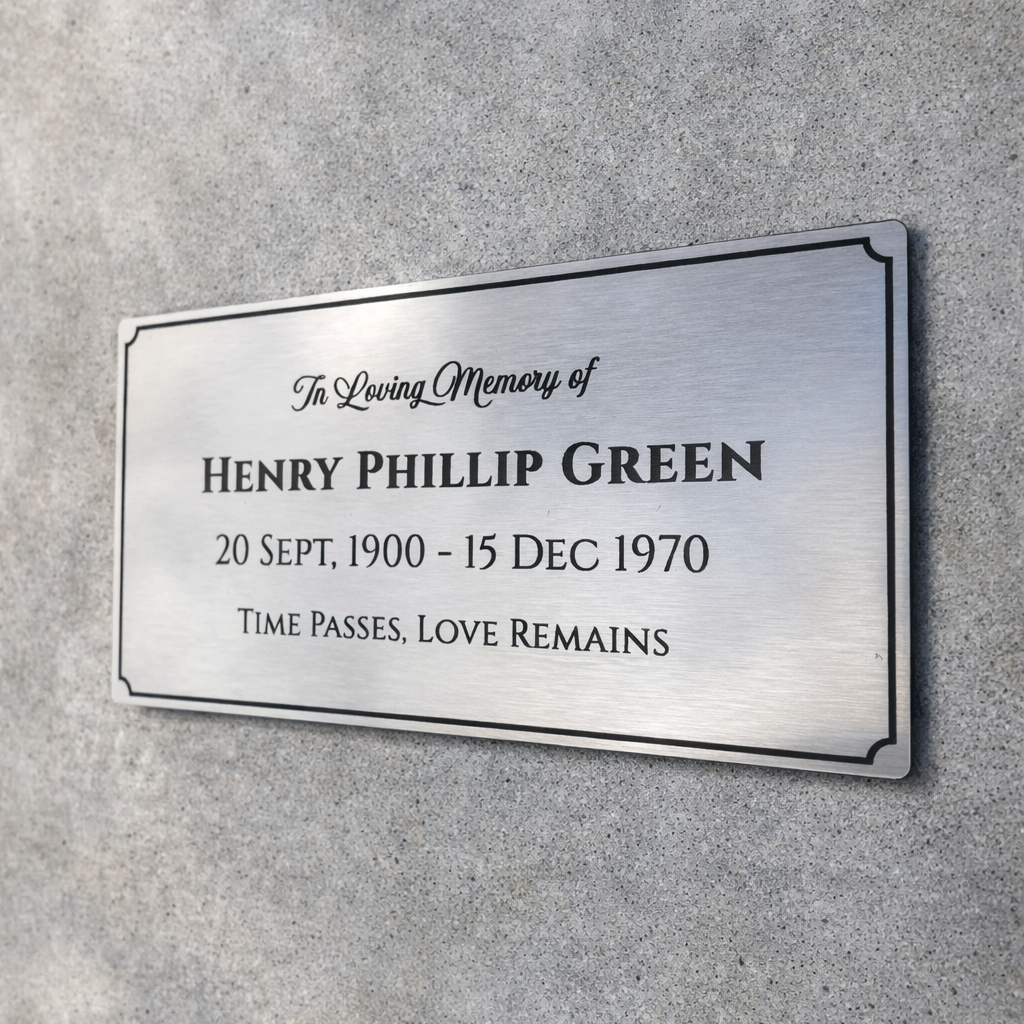 Memorial plaque on a gray wall with engraved text.