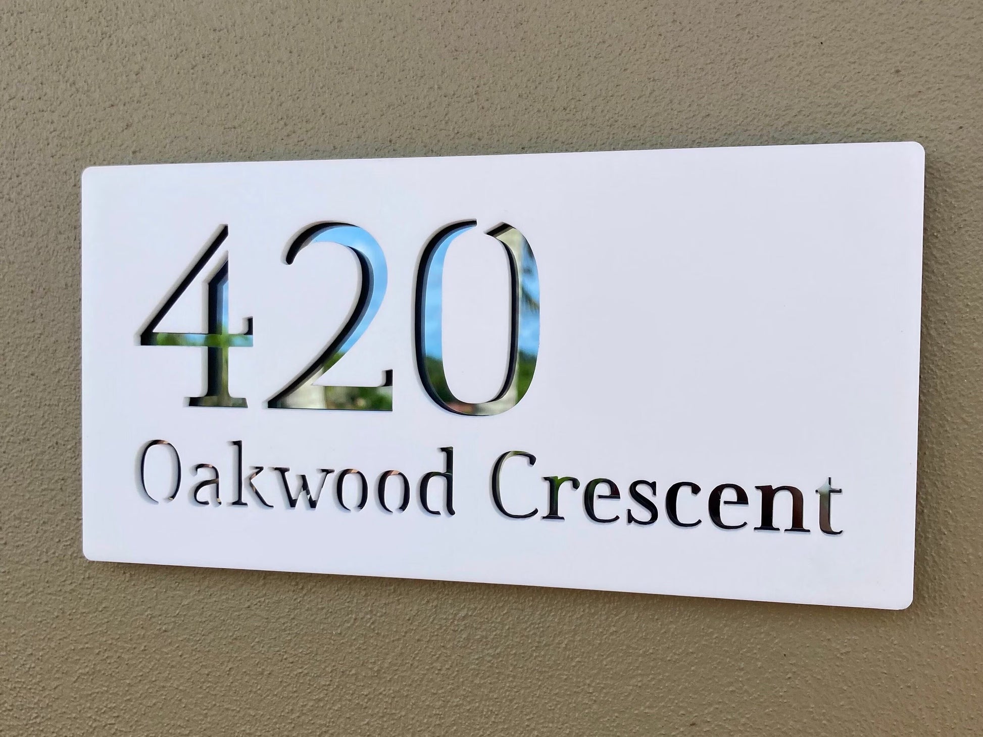 House number sign with '420 Oakwood Crescent' on a beige wall