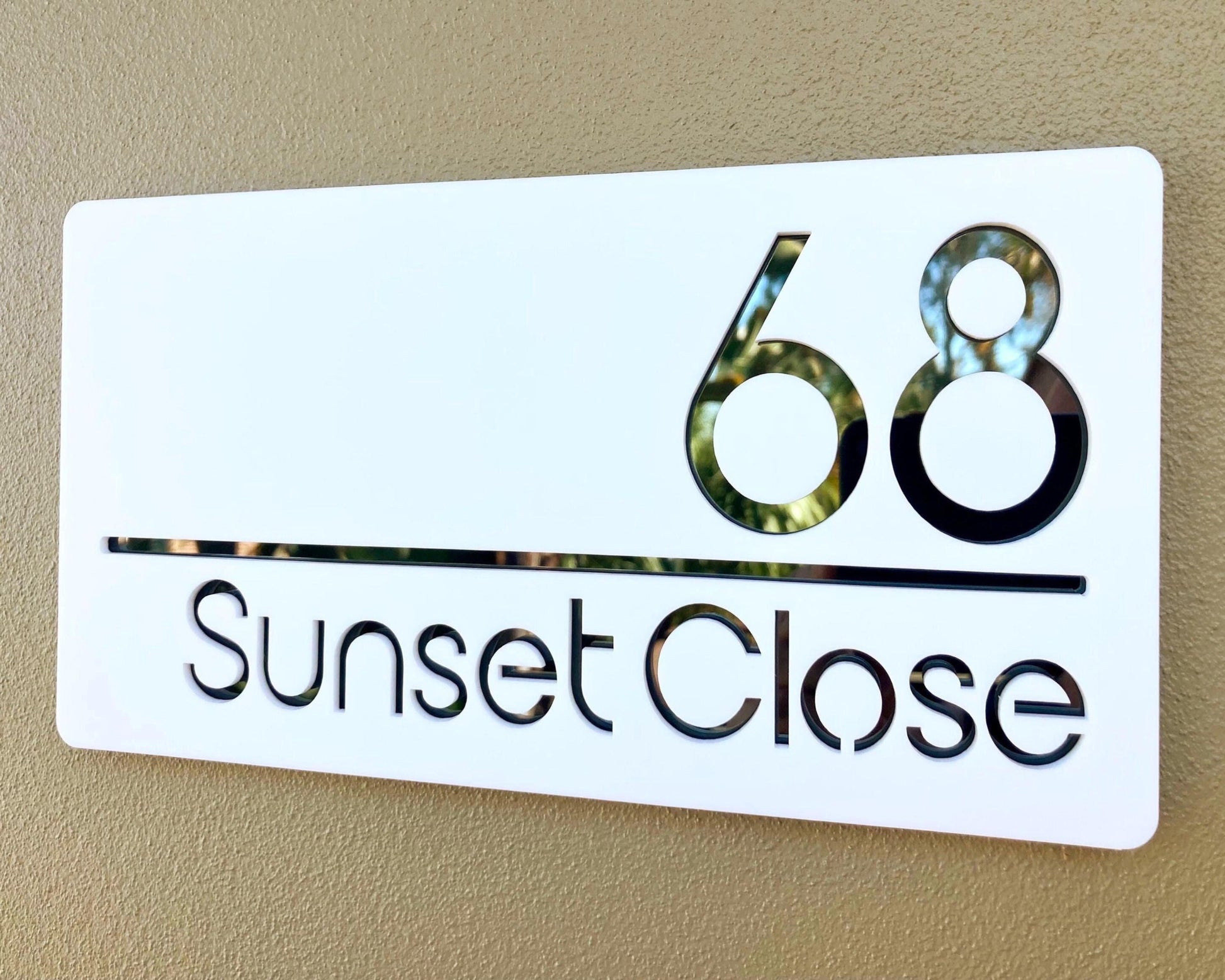 House number sign with '68 Sunset Close' on a beige background